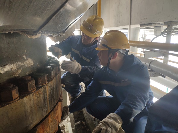 4月6日，機械修造部檢修二部張振華、盧超逸在檢修平臺處，進行4號氣化爐破渣機下降管短節(jié)法蘭螺栓的拆卸工作。.jpg